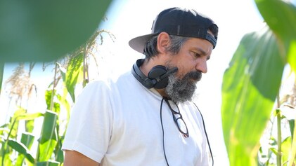 Robin Aubert marche dans un champ de maïs.