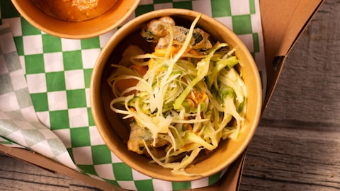 Des légumes tempuras servis avec de la sauce romesco et de la salade de chou.