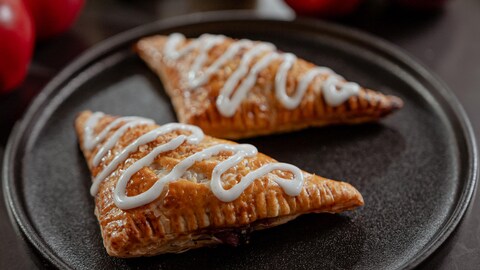 Deux chaussons aux pommes et aux camerises dans une assiette.