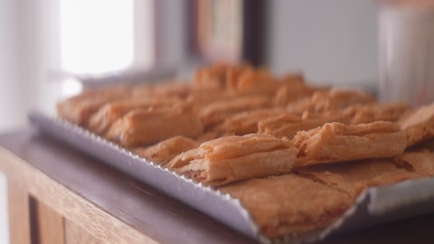 Des carrés de pâte à tarte garnis de compotée de tomates. 