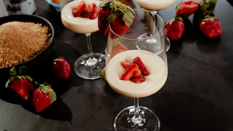 Une mousse à l'érable et au mascarpone servie dans un verre de vin avec des fraises.