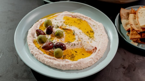 Une tartinade d’œufs de poisson dans une assiette recouverte d'olives et d'huile.