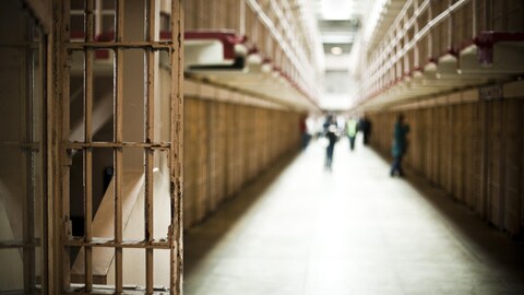 Un couloir de prison et des cellules.