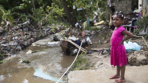 Une jeune fille regarde les dégâts causés par le débordement de la rivière Magua en raison des fortes pluies causées par la tempête Isaias dans la ville de Hato Mayor, au nord-ouest de Saint-Domingue, en République dominicaine, le 31 juillet 2020. (Photo by Erika SANTELICES / AFP) (Photo by ERIKA SANTELICES/afp/AFP via Getty Images)