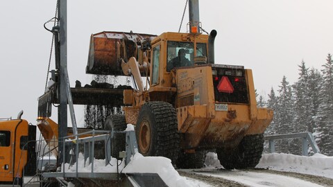Une pelle mécanique charge un camion d'épandage