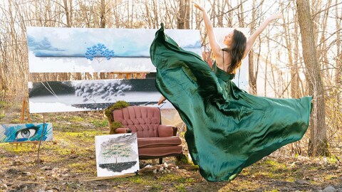 L'artiste porte une grande robe verte et danse devant ses toiles. 