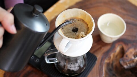 Un barista verse de l'eau sur le café dans le porte-filtre. Un barista verse de l'eau sur le café dans le porte-filtre.