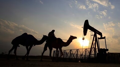A man rides a camel through the desert oil field and winter camping area of Sakhir, Bahrain, in this 2015 photo. The country wants to shift away from emissions-intensive industries to meet climate targets. (Hasan Jamali/The Associated Press)