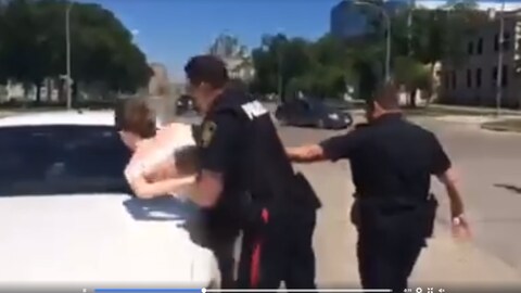 Une capture d'écran d'une vidéo qui montre l'arrestation d'une personne lors de la marche de la communauté transgenre de Winnipeg Une capture d'écran d'une vidéo qui montre l'arrestation d'une personne lors de la marche de la communauté transgenre de Winnipeg