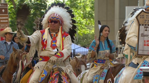 Des Autochtones en tenue traditionnelle défilent sur leurs chevaux. Des Autochtones en tenue traditionnelle défilent sur leurs chevaux.