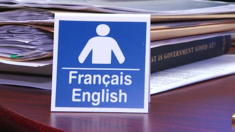 Affichette avec les mots « français » et « anglais » sur un comptoir.