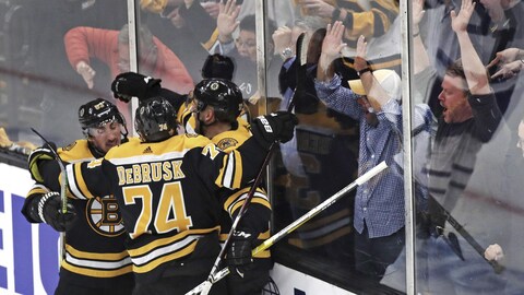 Des partisans des Boston Bruins réagissent avec enthousiasme à un but de Patrice Bergeron.