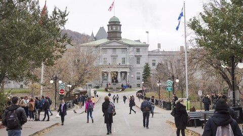 De nombreux passants marchent devant le bâtiment principal de l’Université McGill.