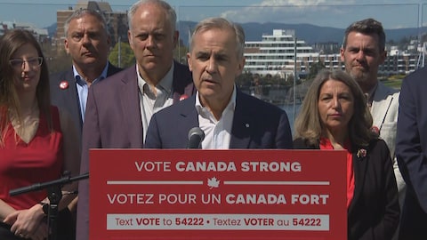 Mark Carney s'adresse aux médias derrière un lutrin.