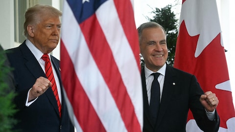 Donald Trump et Mark Carney lèvent le poing et sourient aux photographes de presse.