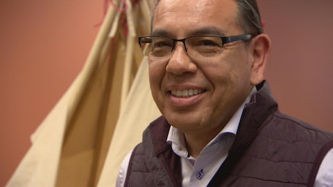 Daren Keewatin apparaît avec ses lunettes en gros plan, avec une chemise fuschia et un large sourire. Daren Keewatin apparaît avec ses lunettes en gros plan, avec une chemise fuschia et un large sourire.
