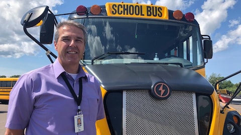 مدير النقل وإدارة المخاطر في فرع المدارس العامة في جزيرة الأمير إدوارد، ديف غيليس، يقف أمام حافلة مدرسية.