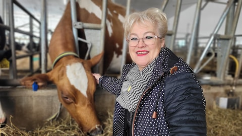 Diane Ouellet Gilbert caresse une vache.