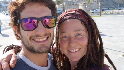 Edith Blais et Lucas Tacchetto posent pour un égoportrait dans une rue ensoleillée.