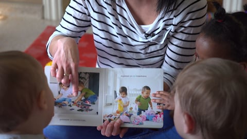 Une éducatrice fait la lecture à des enfants.