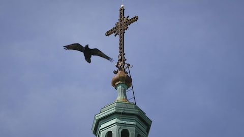 Une croix au sommet du clocher d'une église catholique à Montréal. 