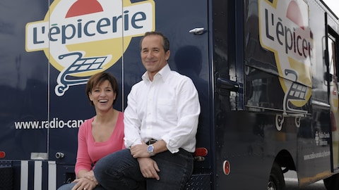 Les animateurs Johane Despins et Denis Gagné assis derrière le camion de « L'épicerie ».