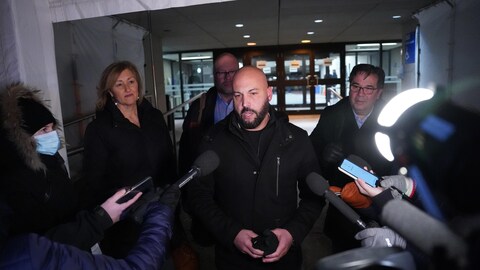Éric Gingras, accompagné de Magali Picard, de Robert Comeau et de François Énault, s'adresse aux journalistes à l'extérieur d'un édifice.