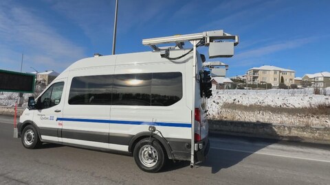Un véhicule du ministère des Transports équipé de plusieurs capteurs roule sur l'autoroute, l'hiver. 
