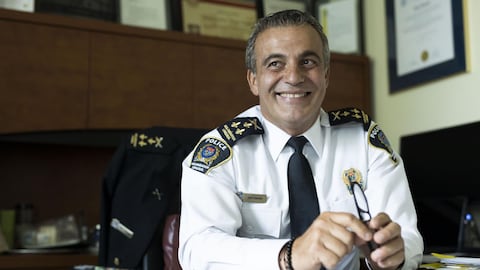 Portrait du policier, grand sourire dans son bureau. 