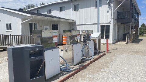 Des pompes à essence sont visibles à l'extérieur d'une station-service fermée.