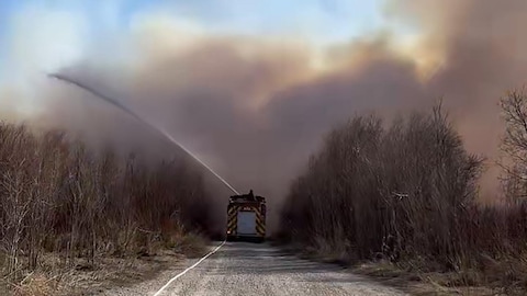 Des pompiers combattent les flammes dans la Nation crie d'Opaskwayak, durant le printemps au Manitoba.
