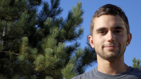 Guillaume Légère, debout devant un arbre sur son terrain.