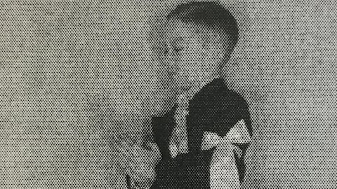 Enfant qui porte un brassard. Il joint les mains et ferme les yeux Enfant qui porte un brassard. Il joint les mains et ferme les yeux