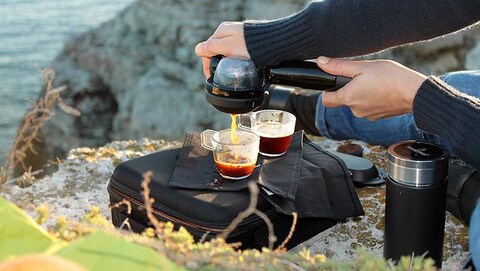Un homme extrait un espresso grâce à un Handpresso. Un homme extrait un espresso grâce à un Handpresso.