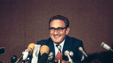 Le conseiller spécial du président américain Nixon, Henry Kissinger, rit lors d'une conférence de presse, après le communiqué final sur la mise en œuvre des accords de paix au Vietnam, signé par Kissinger et le chef de la délégation nord-vietnamienne, Le Duc Tho, le 13 juin 1973 à Paris.