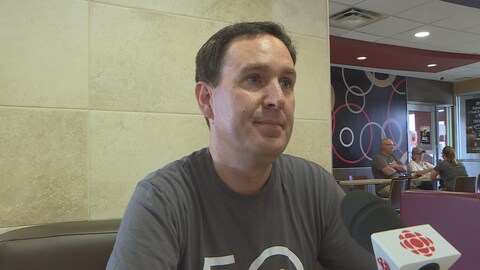 Un homme, assis dans un restaurant, répond à des questions. Un homme, assis dans un restaurant, répond à des questions.