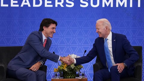 Justin Trudeau sert la main de Joe Biden.