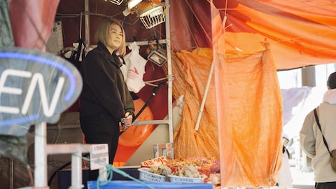 Judy Nguyen derrière un stand dans un marché, dans le village de Steveston, en Colombie-Britannique, en 2024.