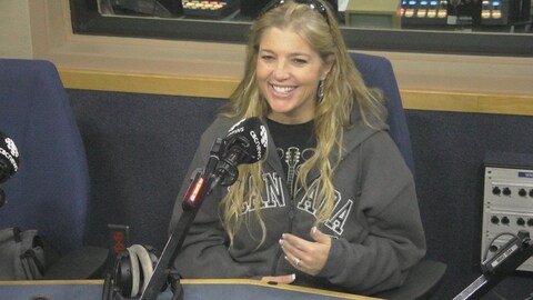 Kathy Tuccaro sourit au micro, dans un studio radio.