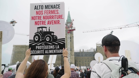 Radio-Canada Une manifestante tient une pancarte devant le parlement d'Ottawa.