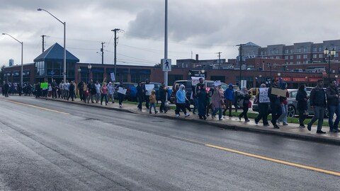 Des manifestants marchent au centre-ville de Moncton.