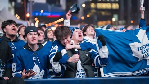 Fans watch the Toronto Maple Leafs play against the Boston Bruins at a tailgate outside Scotiabank Arena on Wednesday night. 