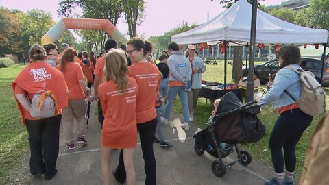 Des manifestants de dos qui marche sur le campus de l'Université Laval. 