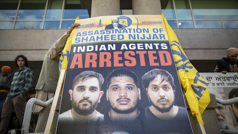 Une pancarte avec les visages des présumés tueurs à gage. 