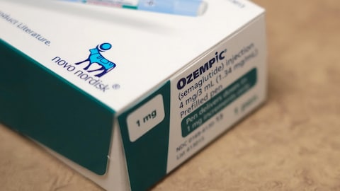 Le coin d'une boîte d'injecteurs Ozempic, avec le logo de l'entreprise pharmaceutique Novo Nordisk, qui est un dessin de taureau bleu.