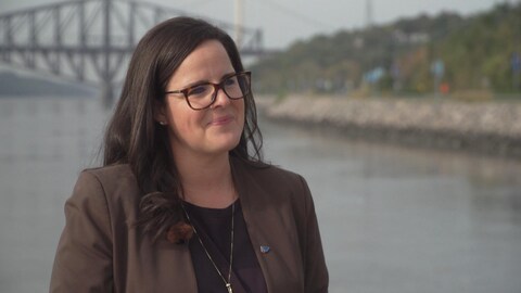 Une femme accorde une entrevue devant les ponts, l'été. 