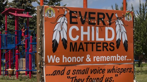 A young girl plays in a park near an Every Child Matters sign in Maskwacis, Alta., Monday, June 27, 2022.