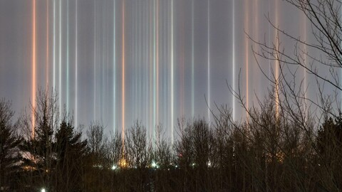 Lumières verticales dans le ciel.