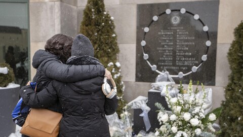 Women take comfort in front of the December 6, 1989 memorial.