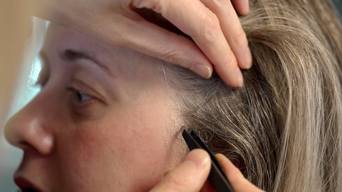 Des cheveux sont prélevés sur la tête d'une femme